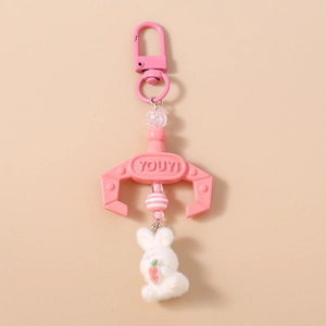 Close-up of pink lobster clasp and cute plush white rabbit with a carrot bag charm