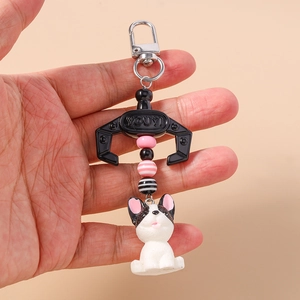 Detail of cartoon French Bulldog keychain featuring decorative beads and metal clasp