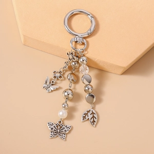 Close-up of silver butterfly and leaf charms on beaded keychain with spring ring clasp