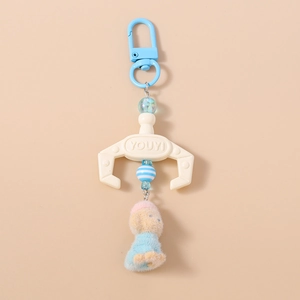 Detail of plush dog keychain featuring a blue claw arm design and colorful beads