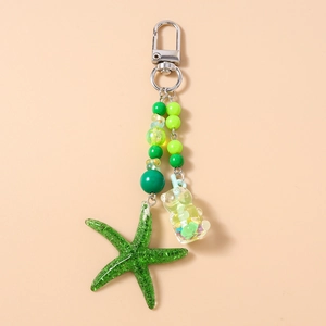 Détail du porte-clés à perles vertes avec étoile de mer brillante et breloque ours