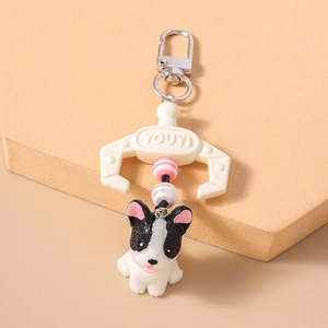 Close-up of French Bulldog keychain with paw controller charm and pink beaded accents