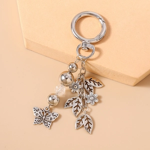 Detail of silver beaded keychain with engraved butterfly, leaves and flower charms