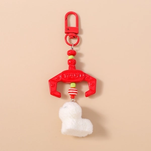 Detail of red crane machine claw keychain with white plush dog pendant and red lobster clasp