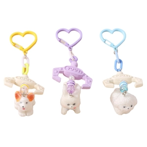 Three plush dog keychains with heart hooks and colorful claw machine designs on white background