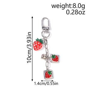 Detail view of strawberry keychain with silver clasp, bell and size labels shown