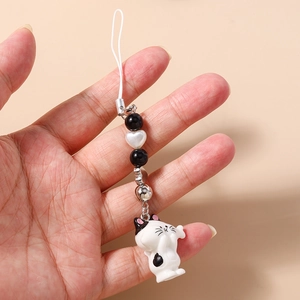 Detailed macro view of a cute beaded cat phone strap with heart charm and small metal bell