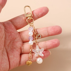Detailed shot of ocean-themed beaded keychain with pearl, purple bead, and resin starfish