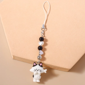 Close-up of beaded phone charm with white cartoon cat pendant and heart bead detailing