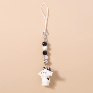 Detailed close-up of a cute white cat phone charm with black beads and a heart bead accent