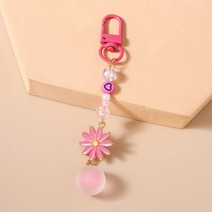 Détails d'un porte-clés à perles roses avec breloque marguerite et sphère mate douce