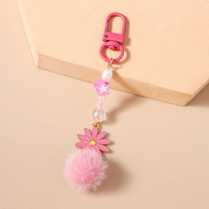Vue détaillée du porte-clés rose perlé avec breloque marguerite et boule peluche