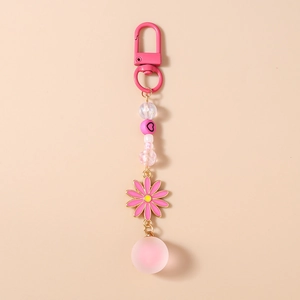 Détail d'un porte-clés perlé rose avec breloque marguerite et perle ronde pour sac à main