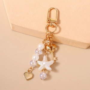 Detail of beaded keychain with starfish, pearls and heart charms on a lobster clasp