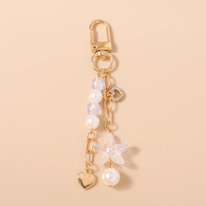 Detail of beaded keychain with gold heart pendant, ocean starfish, and pearls