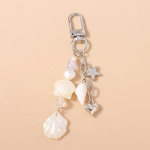 Detailed shot of pearly shells, crystal beads, and silver metal heart charms on a keychain