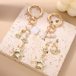 Porte-clés doré avec perles, pendentif ancre et breloque étoile sur socle en pierre