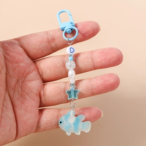 Detail of light blue beaded keychain with heart beads and a clownfish pendant