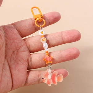 Detail of beaded clownfish keychain with orange lobster clasp and star charms
