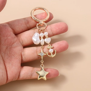 Détail du porte-clés doré avec perles, breloque étoile et élément d'ancre marine