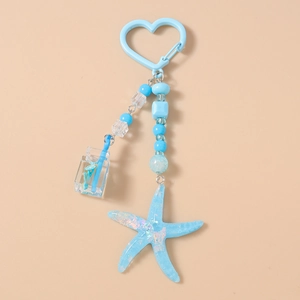 Detailed view of ocean-themed blue keychain with starfish and drink bottle charms