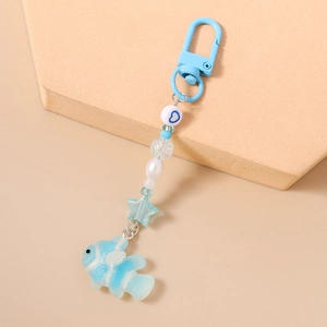 Detail of light blue beaded keychain featuring a fish pendant and star-shaped beads
