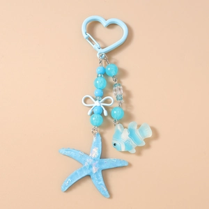 Detail of ocean-themed keychain with starfish, tropical fish pendants and a blue heart hook
