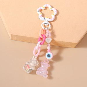 Detail of macaron bead keychain featuring gummy bear pendants and evil eye charm accents