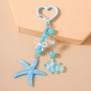 Close-up of ocean-themed blue resin keychain with starfish, tropical fish and beads