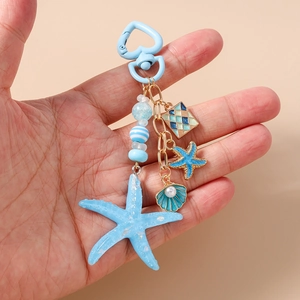 Detailed shot of ocean-themed keychain featuring blue starfish and pearl shell charms