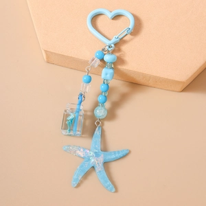 Detail of blue starfish keychain with beads, heart clasp, and mini drink bottle charm