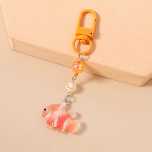 Macro detail of a fish keychain with orange gradient clownfish charm and beaded accents