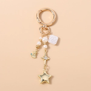 Détail d'un porte-clés doré avec perles, breloque coquillage et éléments d'étoile en cristal