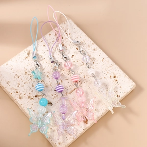 Close-up of colorful beaded butterfly phone charms in pastel resin on stone stand