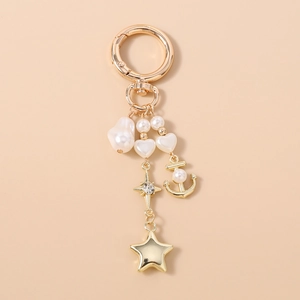 Vue détaillée du porte-clés ancre dorée avec pendentifs perles et breloque étoile cristal