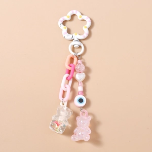 Detail of pink resin bear pendants with colorful beads and patterned clasp on a chain