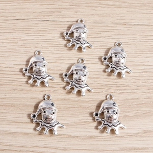 Set of 6 vintage silver clown pendants for DIY jewelry making on a wooden background
