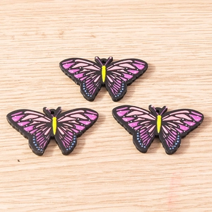 Macro view of colorful painted wooden butterfly charms for DIY jewelry and crafts