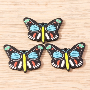Three colorful butterfly charms with floral patterns and top holes for DIY jewelry making