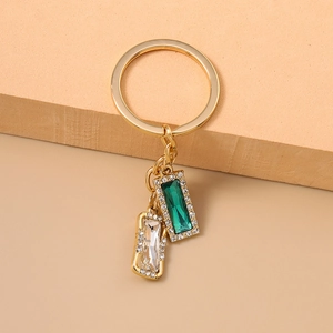 Fashion gold keychain with green and clear square rhinestones on warm background