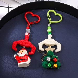 Christmas beaded keychains with Santa Claus and Xmas tree charms in a blue tray