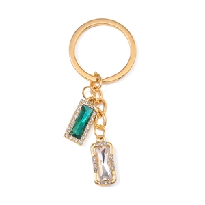 Golden keychain with emerald and clear square crystal pendants on a white background