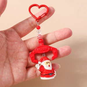 Close-up of a Santa Claus beaded keychain with a red mechanical claw and heart clasp