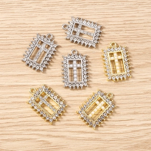 Detailed view of gold and silver rectangle cross charms with pearls and rhinestones