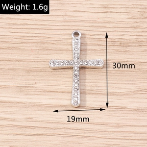 Macro detail of a 30mm rhinestone cross pendant with 1.6g weight and silver finish