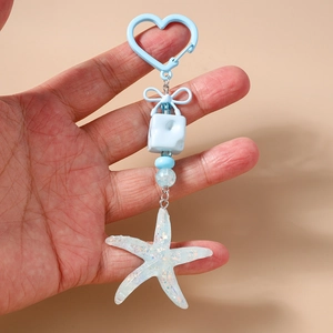 Detail of blue heart-shaped clasp and transparent glittery starfish pendant charm