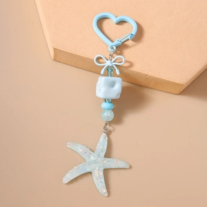 Detail of light blue starfish keychain with glitter resin pendant and heart clasp