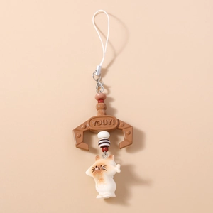 Close-up of brown claw machine cat pendant with a detailed resin kitten and silver clasp