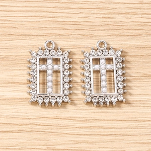 Macro shot of silver plated rectangular pendants with pearl cross and rhinestone frame