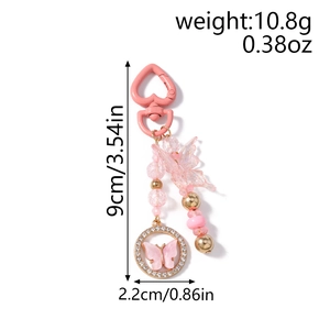 Détail du porte-clés papillon rose avec fermoir cœur, perles et strass brillants